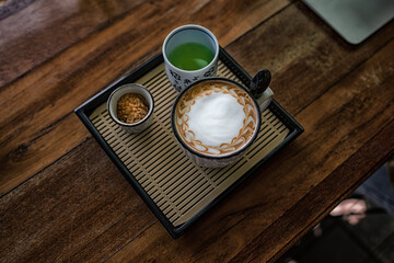 Hot coffee cup on wood table in cafe.