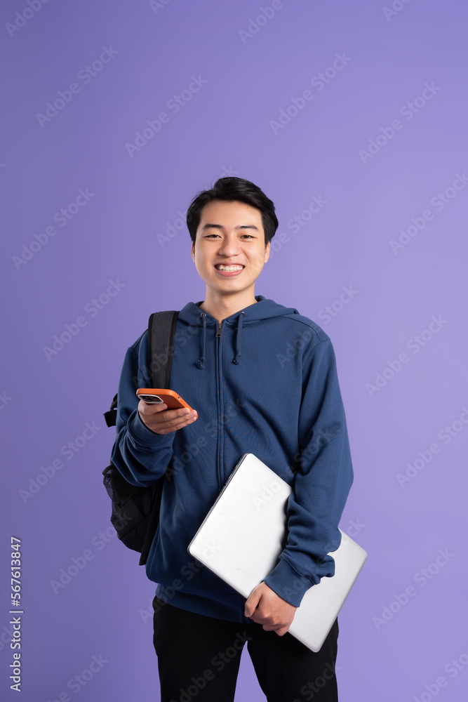 Wall mural Asian male student portrait on purple background - Wall murals