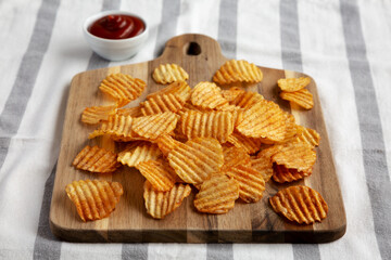 Barbeque Potato Chips on a wooden board, low angle view.