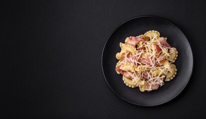 Delicious pasta with bacon and parmesan cheese on a black ceramic plate