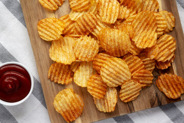 Barbeque Potato Chips on a wooden board, top view. Flat lay, overhead, from above.