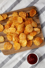 Barbeque Potato Chips on a wooden board, top view. Flat lay, overhead, from above.