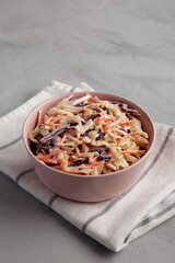 Homemade Classic Southern Coleslaw in a pink Bowl, low angle view.