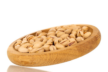 Many peeled pistachios in a wooden bowl, close-up, isolated on white.