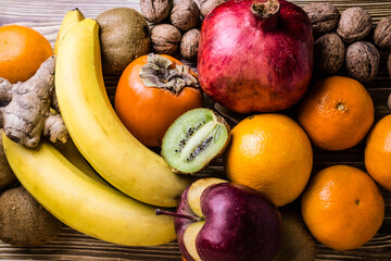  persimmon, orange, banana, tangerine and other fruits on a wooden surface