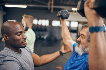 Fitness, old man and personal trainer coaching with dumbbell weightlifting, muscle support and gym...