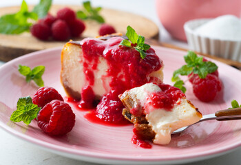Cheesecake with red fruit sauce and fresh fruit such as raspberries, blueberries or strawberries.