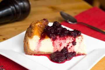 Cheesecake with red fruit sauce and fresh fruit such as raspberries, blueberries or strawberries.