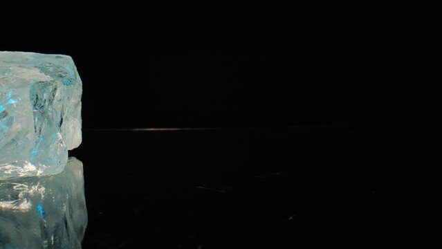 Cinematic blue-lit macro shot of glistening white quartz slowly gliding across a dark background, captured through smooth motorized slider movement.
