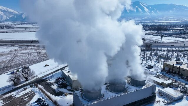 Aerial electric power generator complex steam circle 2 . Natural gas fired power plant and city sewer treatment ponds Utah winter snow. Buildings, towers, cooling and water storage. Clean.