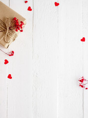 Valentine's Day flatlay. Gift box of craft paper with hearts on the white wooden background.