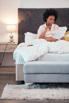 Black woman, pregnant and bed with paperwork, thinking or writing letter for maternity leave at home. African American female with pregnancy papers contemplating document or schedule plan in bedroom