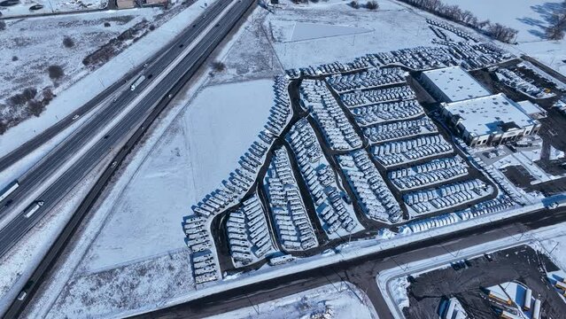 Aerial recreation vehicle RV sales business winter snow. Over stocked dealer due to economic and COVID. Cold winter season weather, white snow and ice on homes, city, rural and farming community.