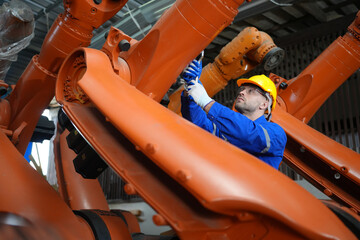 Engineer check and control welding robotics automatic arms machine in intelligent factory automotive industrial with monitoring system software. Digital manufacturing operation. Industry 4.0