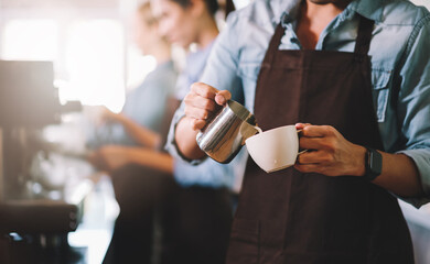 Barista man making cappuccino, latte art preparing coffee hot drink for customer at cafe.