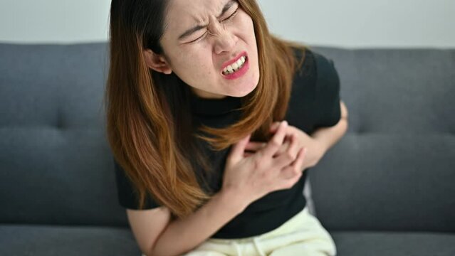 Asian woman having heart attack problem. A heart attack occurs when an artery that sends blood and oxygen to the heart is blocked.