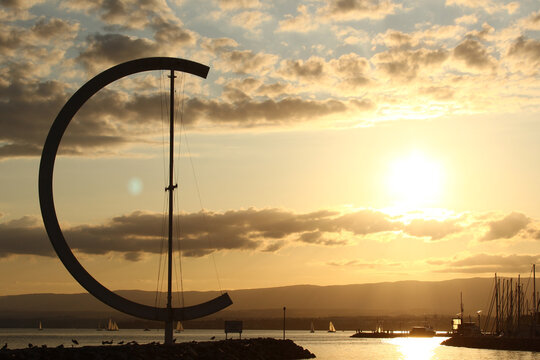 Lausanne, Switzerland - July 31, 2019: The marina Ouchy in Lausanne, during sunset with the wind vane Eole at the left side