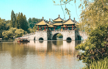 Craft sailing towards Wuting Bridge in Slender West Lake in sunny days. Chinese characters on the...