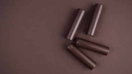 Battery. Cylindrical battery, type 18650 on a brown background. Rechargeable lithium-ion batteries for electrical appliances and devices.