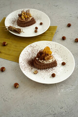 delicious cakes with cream filling and nuts on white plates. chocolate cake on a plate.