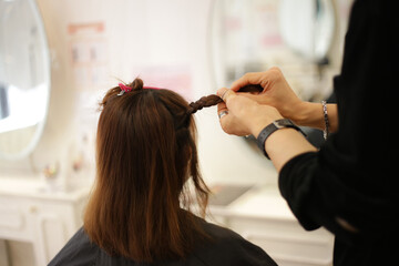 Naklejka premium 女性の髪を結ぶ男性美容師