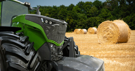 Agricultural tractor on a background of straw bales 