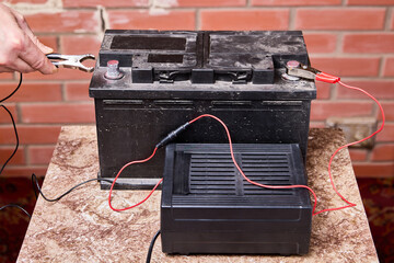 Car battery charger connects to cleat with an alligator clip.