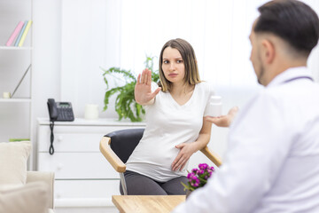 Photo of pregnant woman reaching out to doctor.