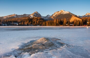 Winter landscape of a frozen mountain lake on a frosty sunny day. Location place Strbske pleso, High Tatras national park, Slovakia, Europe. Vibrant photo wallpaper. Discover the beauty of earth.