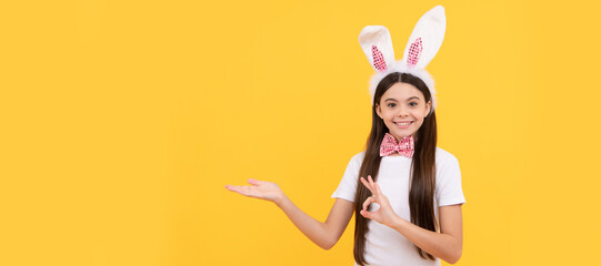 teen girl in bunny ears presenting product or shopping sales. Easter child horizontal poster. Web...