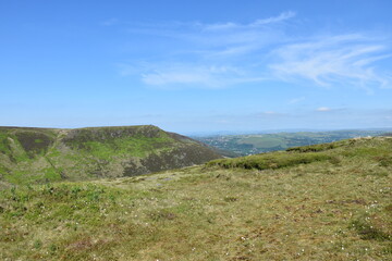 Fototapeta premium View from the top of a mountain with green fields and a blue sky background. Taken in Oldham England. 