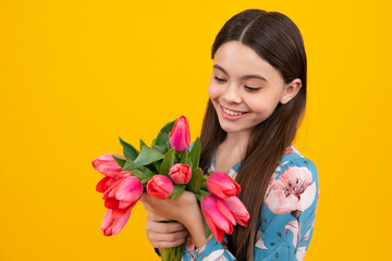 Obraz na płótnie Canvas Beautiful smiling trendy teen girl with bouquet of tulips on yellow studio background. Girl enjoying flowers.