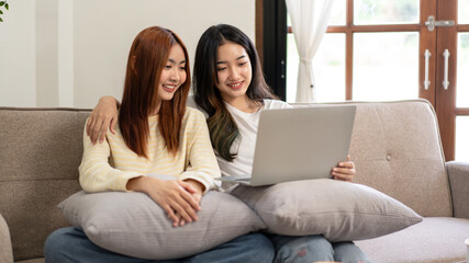 Young woman lesbian couple sitting to embracing and watching mov