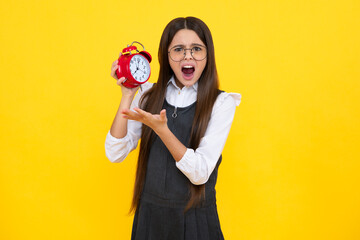 Fototapeta premium Punctual teen girl checking time. Child with alarm clock showing time. Angry teenager girl, upset and unhappy negative emotion.