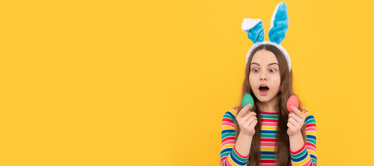 I feel shocked. child in rabbit ears hold painted eggs. time for fun. adorable funny kid on egg hunt. Easter child horizontal poster. Web banner header of bunny kid, copy space.