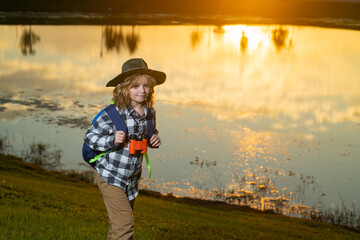 Kid with binoculars hiking at nature. Little explorer. Outdoor recreation and adventures with kids....