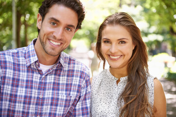 Fototapeta premium Park, portrait and couple on a outdoor date with happiness and love together in nature. Sunshine, vacation and fun with a smile in summer on holiday feeling relax in the sun with blurred background