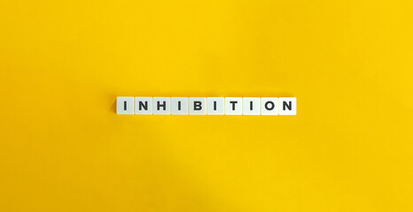 INHIBITION Word on Block Letter Tiles on Yellow Background. Minimal Aesthetics.