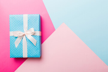 holiday handmade paper present tied white ribbon bow top view with copy space. Flat lay holiday background. Birthday or christmas present. Christmas gift box concept with copy space