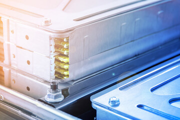 a close-up photo of an assembled EV battery module. Through the technological window in the...