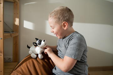 Boy playing with robotic dog, laughing, tickling pet