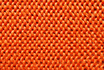 Orange color ornamental knitted surface texture as background
