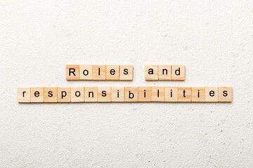 roles and responsibilities word written on wood block. roles and responsibilities text on table, concept - obrazy, fototapety, plakaty