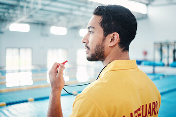 Lifeguard, whistle and swimming pool safety by man watching at indoor facility for training, swim and practice. Pool, attendant and guy water sports worker monitoring exercise, danger and swimmer