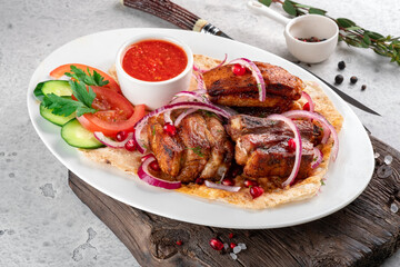 Pieces of pork kebab on a plate with pita bread and fresh vegetables. Grilled Pork Dishes