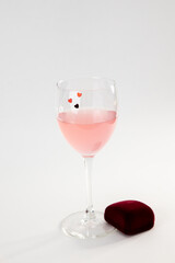 photo of a transparent wine glass with a pink drink on a light background