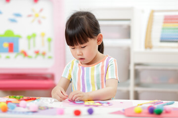 young girl making paper craft for homeschooling