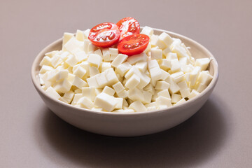 Plate with Italian cow mozzarella cheese cut into cubes for pizza preparation (selective focus) - obrazy, fototapety, plakaty