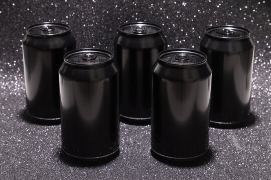 Photo of five black blank aluminium cans, front view (selective focus)