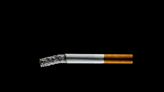 Sigaretta che si consuma sospesa nel vuoto su fondo nero